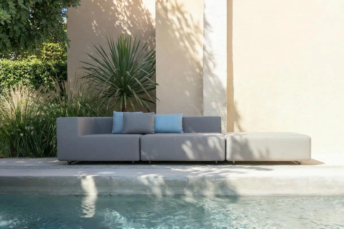 -Sitzgruppe LOOP mit gemütlichen Kissen für den Garten auf Holzterrasse am Wasser.