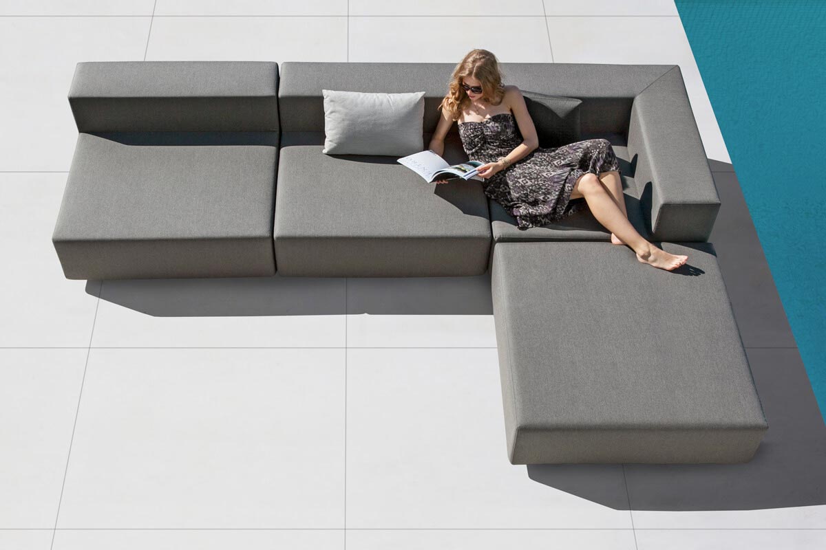 Frau liest entspannt auf einem sehr bequemen, 3-teiligen Design-Gartenmöbel Set im Outdoorbereich