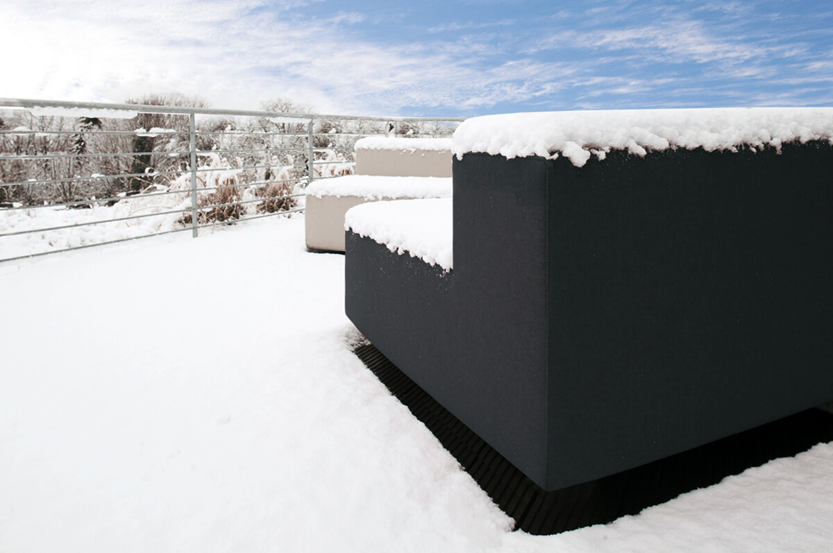 Wetterfeste, schneebedeckte Lounge Gartenmöbel auf einem verschneiten Balkon