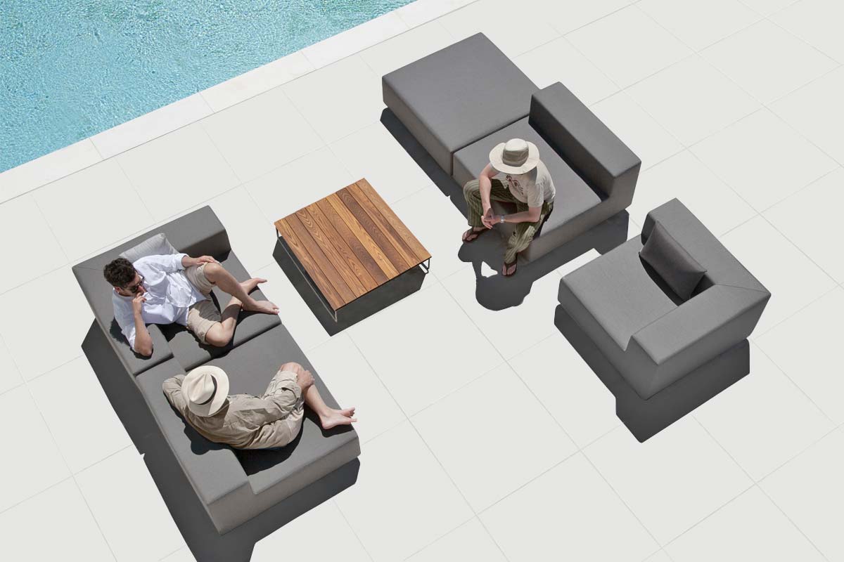 3 Personen unterhalten sich entspannt auf einem 3-teiligen Lounge Set mit Outdoortisch auf der Terrasse